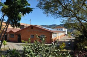 Cortes do governo ameaçam o funcionamento das Instituições Federais de Ensino Têm sido difíceis os tempos atuais para as Instituições de Ensino e Pesquisa Federais, onde se incluem os IFs e as Universidades. Depois de cerca de 13 anos com investimento público significativo, desde o governo Temer a situação se torna cada vez mais caótica. A lei orçamentária de 2021 foi sancionada por Bolsonaro com veto de quase R$ 30 bilhões à proposta aprovada no congresso. Só para a Educação, a redução foi de R$ 3,9 bilhões, impactando diretamente o funcionamento das escolas e universidades. Como tivemos dois anos de pandemia, com aulas remotas e poucas atividades presenciais, apertando o cinto foi possível garantir as ações mínimas das autarquias, mesmo com cortes em bolsas de pesquisa e extensão. Agora, com o retorno das aulas presenciais, é preciso que se tenha um orçamento mínimo para que estes locais possam funcionar, entretanto, de maneira surpreendente, o governo Bolsonaro se supera e apresenta no Projeto de Lei Orçamentária Anual (PLOA) de 2022 uma redução ainda maior que 2021. O relator do projeto, Deputado Hugo Leal (PSD-RJ), propõe cortar 5,8% da verba das universidades federais e 5,5% das bolsas de pesquisa do CNPq (Conselho Nacional de Pesquisa e Desenvolvimento Científico). Isso significa um impacto negativo de mais R$ 473 milhões para os IFs e universidades. Segundo dados da Associação Nacional dos Dirigentes das Instituições Federais de Ensino Superior (Andifes), as instituições de ensino públicas necessitam de, no mínimo, R$ 1,8 bilhão a mais do que o previsto para funcionarem em 2022, isso significa que estamos a ponto de entrar em colapso! Este colapso, significa menor qualidade na prestação de serviços, impactando diretamente a população brasileira, que é quem depende de um serviço público de qualidade, em especial os menos favorecidos economicamente. Imagina um estudante ter que pagar de 10 a 15 reais no bandejão? Isso é surreal! É preciso que todos entendamos que isso tudo não é por acaso, tem por trás um projeto, que vem desde 2016 com a Emenda Constitucional (EC) 95 que congelou por 20 anos os investimentos públicos. O objetivo é exatamente isso que estamos vendo: implodir o serviço gratuito e universal para entregar de mão beijada para a iniciativa privada, que é a quem servem muitos deputados federais, afinal foram eles que financiaram as suas campanhas nas eleições legislativas. Mesmo sabendo disso, é preciso resistir, os modelos de IFs que nós temos dão (e muito) certo, estão entre os 30 melhores modelos escolares do mundo, isso não é pouca coisa. Sem contar nossas Universidades, que estão sempre bem pontuadas nos rankings globais. Não podemos aceitar o que querem fazer conosco, é hora de pressionar nas redes por mais verbas para as instituições federais no ano que vem e defendê-las dos ataques dos tubarões interessados em destruir nosso sistema gratuito e universal de ensino e pesquisa. Em 2022, quem defende a escola pública tem que se posicionar, é hora de mostrar também nas ruas que não apoiamos os atuais detentores do poder!
