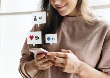 Como fidelizar clientes no marketing digital. Foto: Mulher usando um smartphone. Reprodução/Freepik